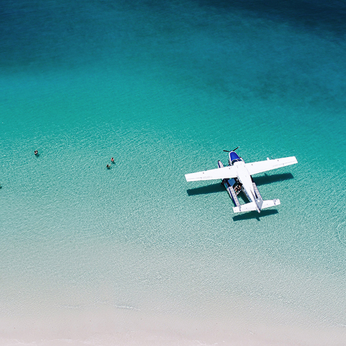 Aerial view of a seaplane in the turquoise waters of Whitehaven Beach