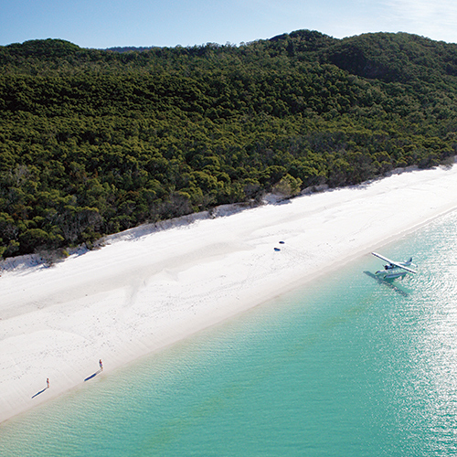 View of luxury sea plane landing on waters as part of qualia's Whitehaven Beach Tour 