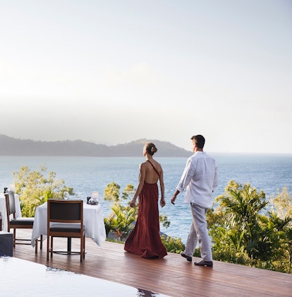 qualia Resort Couple Walking Through Outdoor Dinner Tables at Long Pavilion Restaurant with Whitsundays Views
