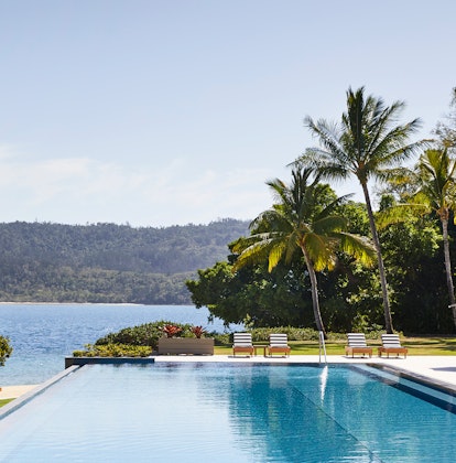 qualia Resort Pebble Beach infinity pool with palm trees, sun lounges and Whitsundays views