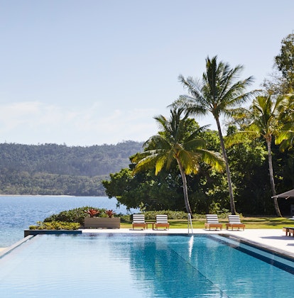 qualia Resort Pebble Beach infinity pool with palm trees, sun lounges and Whitsundays views