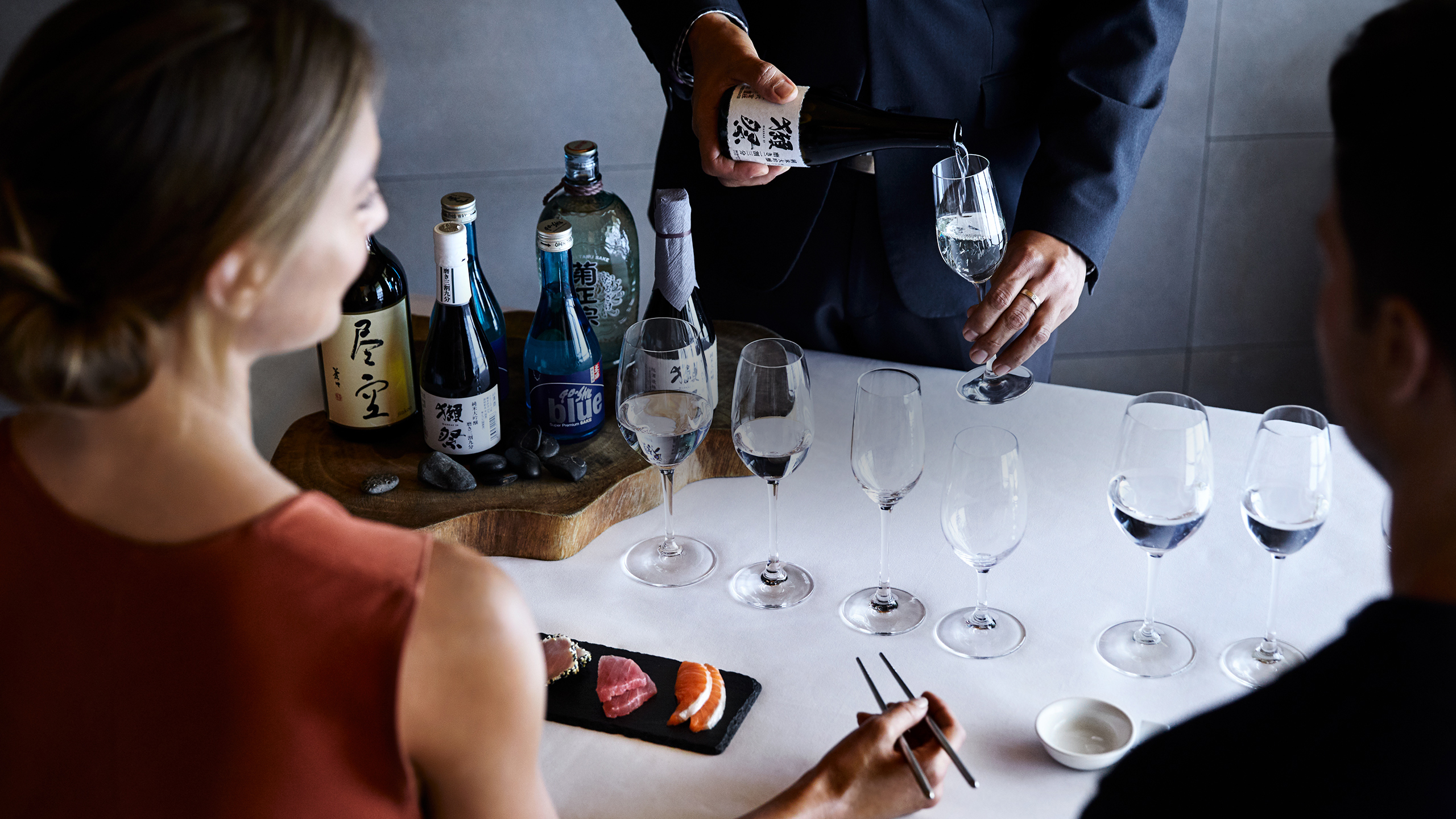 Qualia Resort Talk and Taste Experience with man and woman enjoying sushi and sake tasting