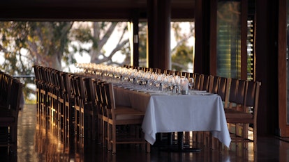 Long table and chairs for corporate retreat with sunlight coming through the window at qualia's Long Pavilion 