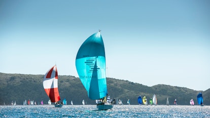 Stratacare blue sailboat ahead in the Hamilton Island Race Week followed by a red and white sailboat