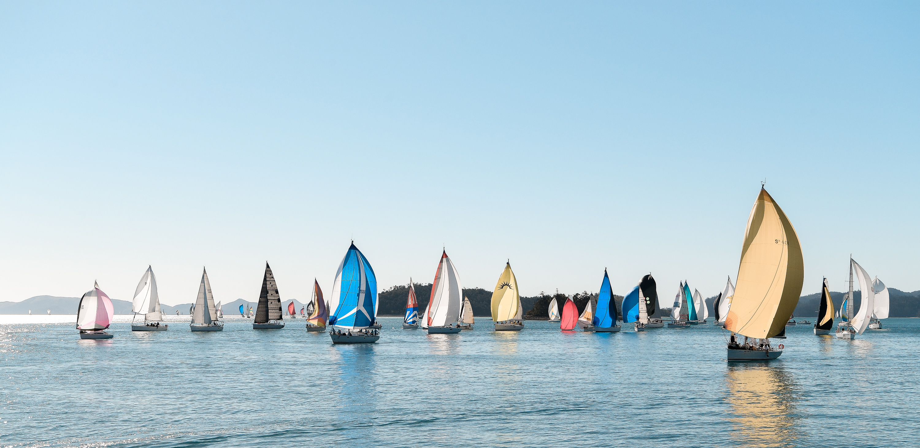 A group of colored sailing fleet in the Whitsundays during Hamilton Island Race Week