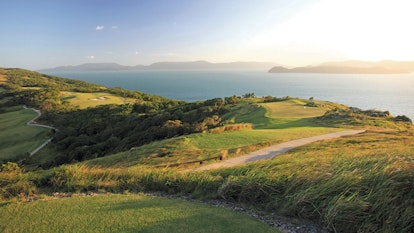 qualia View across Hamilton Island Golf Course with sunlight pouring across from neighbouring Whitsunday island