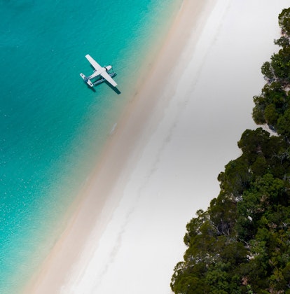 Aerial view of luxury sea plane landing on waters as part of qualia's Whitehaven Beach Tour 
