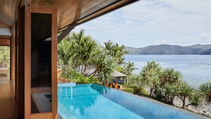 qualia resort Beach House with accordion windows opened up to show infinity pool and Whitsundays views